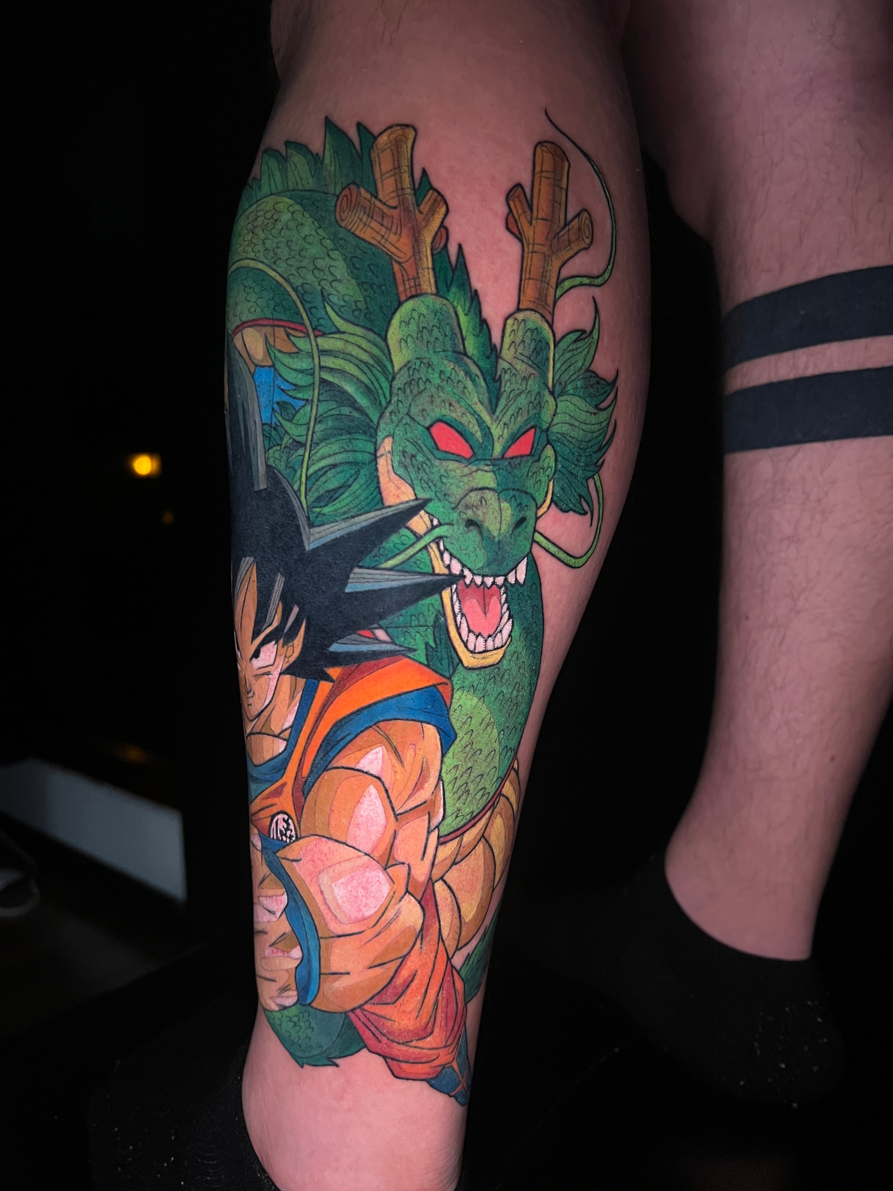 Tatuaje anime de Goku con Shenron a color en el antebrazo