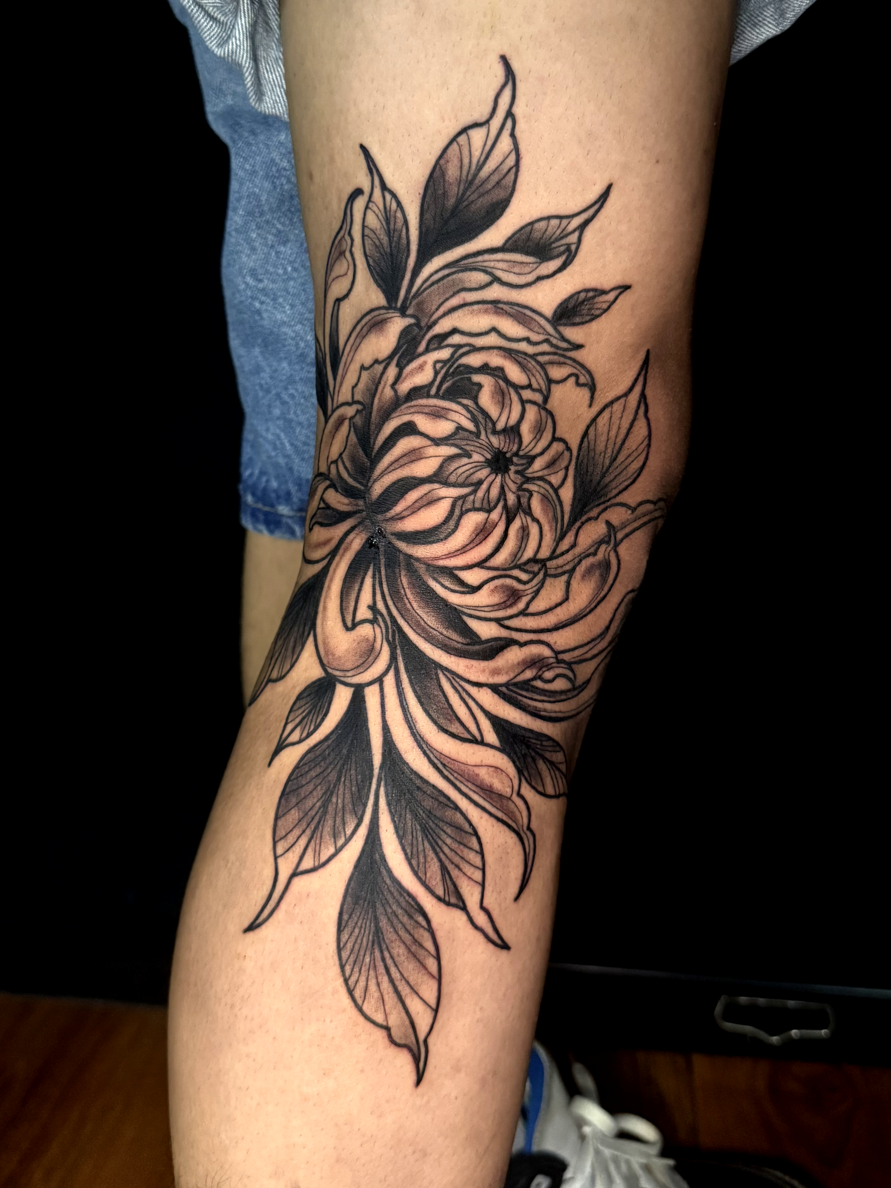 Tatuaje blackwork floral en pierna