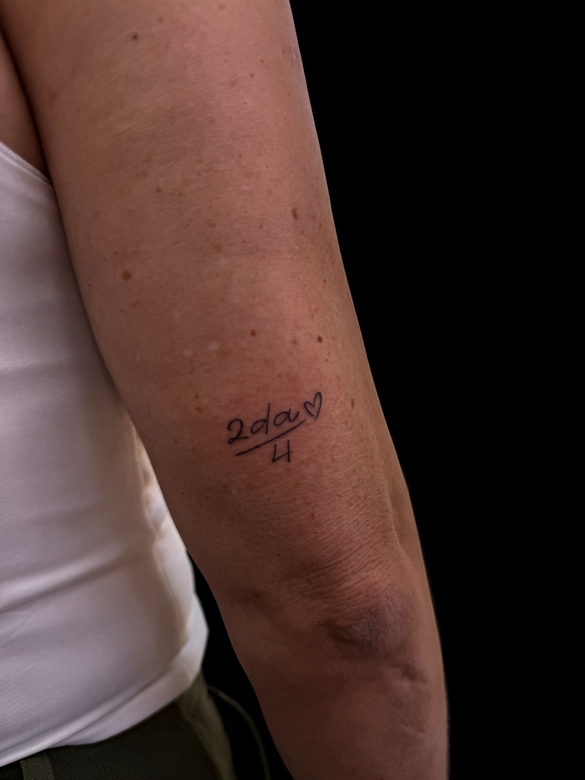 Tatuaje fineline con texto 2da/4 en brazo