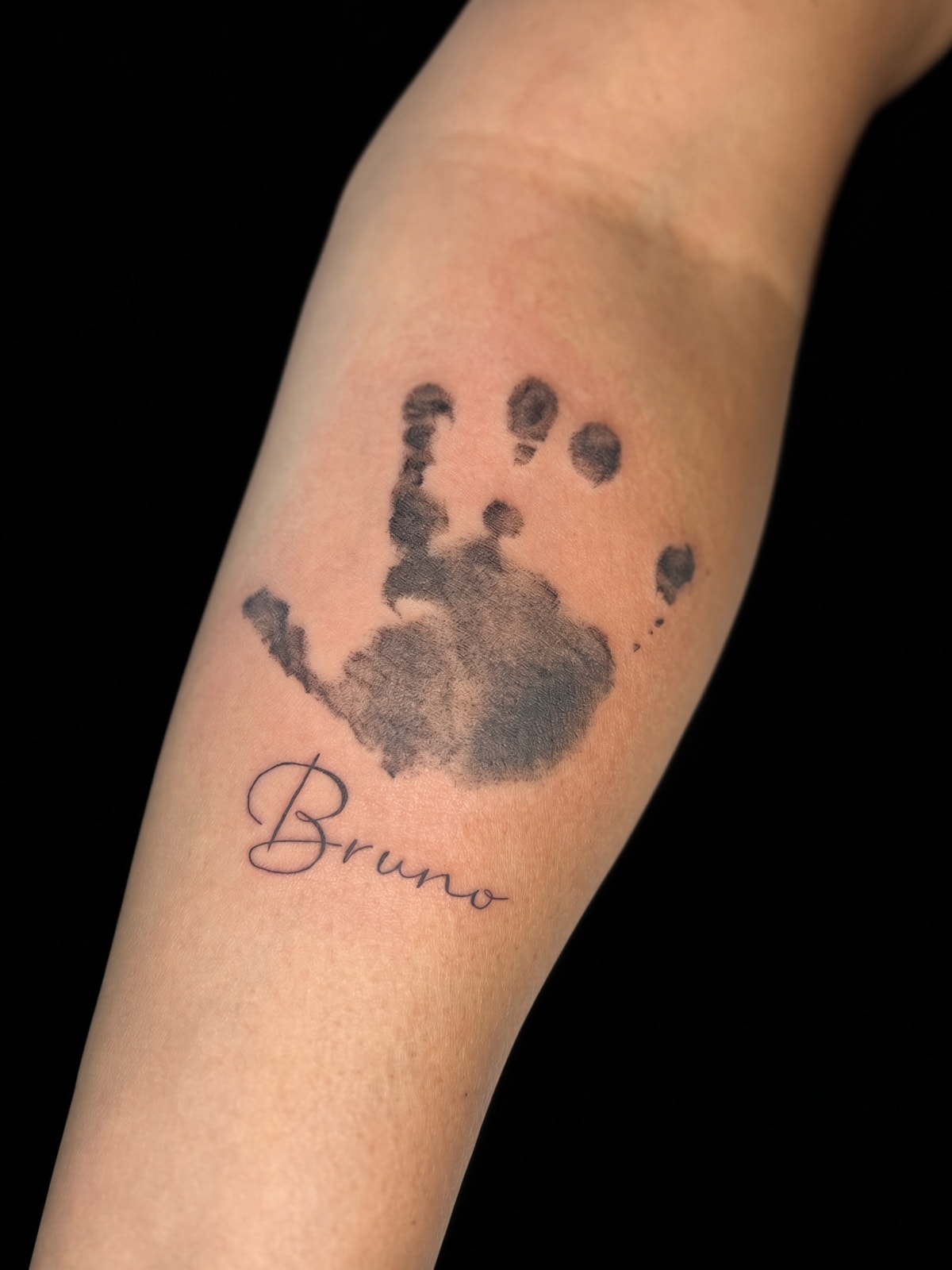 Tatuaje fineline de huella de mano con nombre Bruno