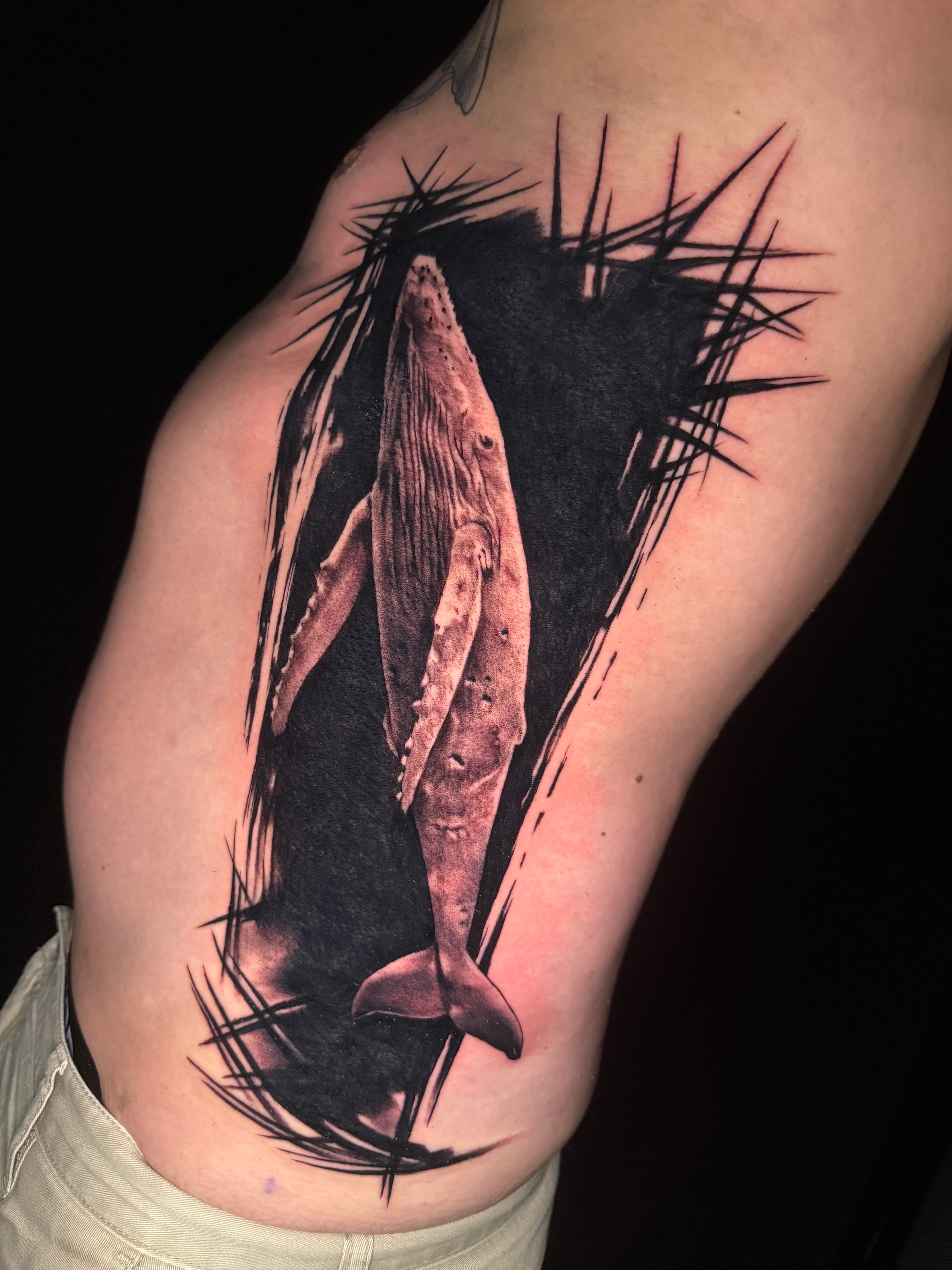 Tatuaje estilo libre de ballena en blackwork en el brazo