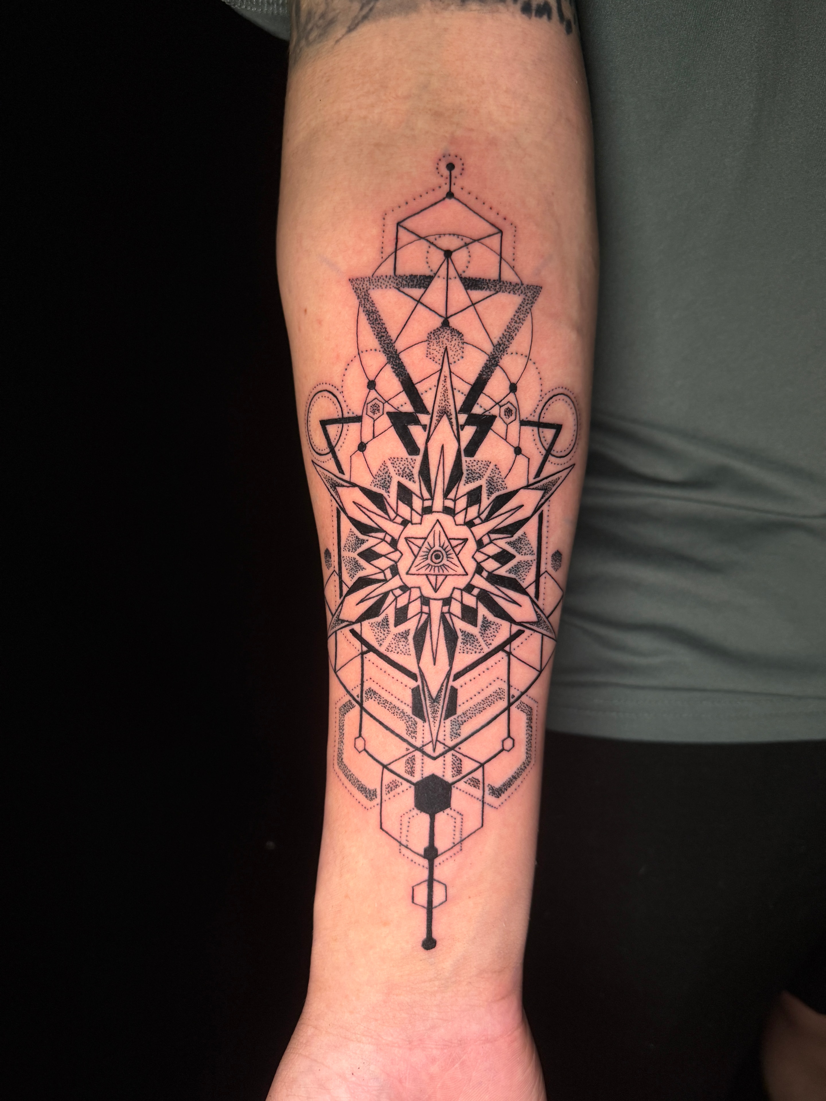 Tatuaje geométrico negro en antebrazo