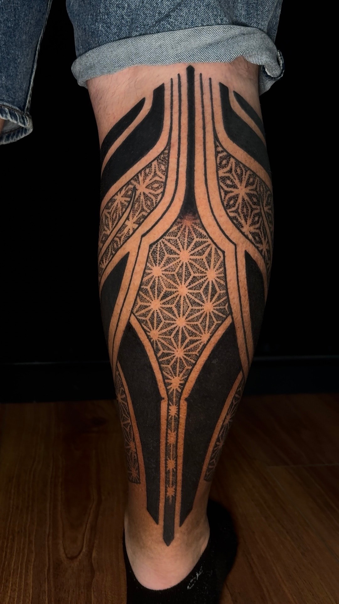 Tatuaje blackout geométrico frontal en pierna