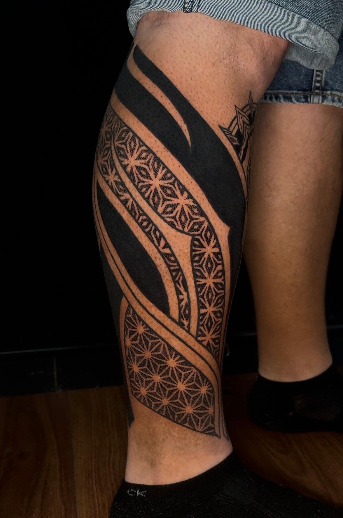 Tatuaje blackout geométrico en pierna