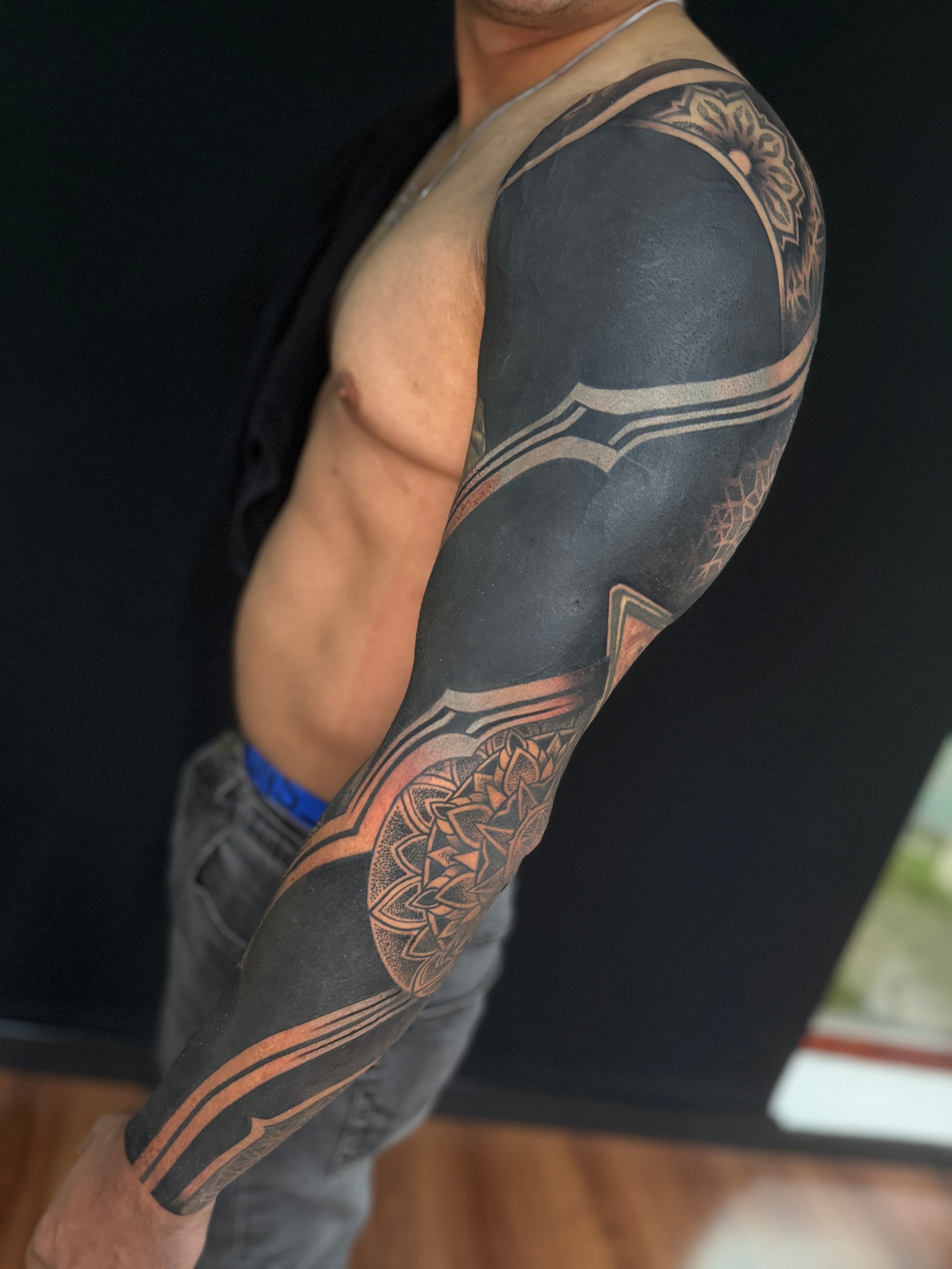 Tatuaje blackout geométrico de manga completa