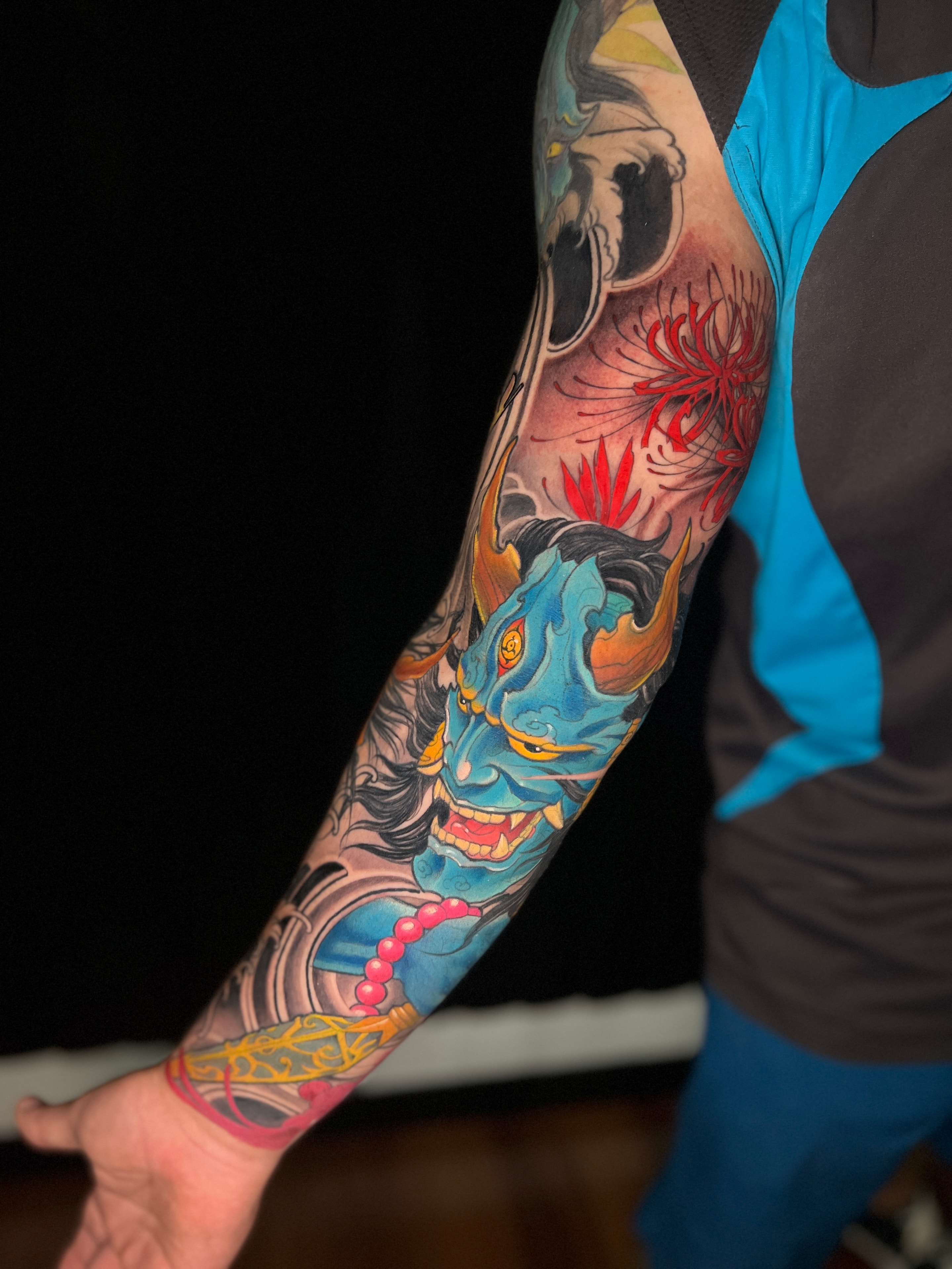 Tatuaje japonés de oni azul en manga de brazo
