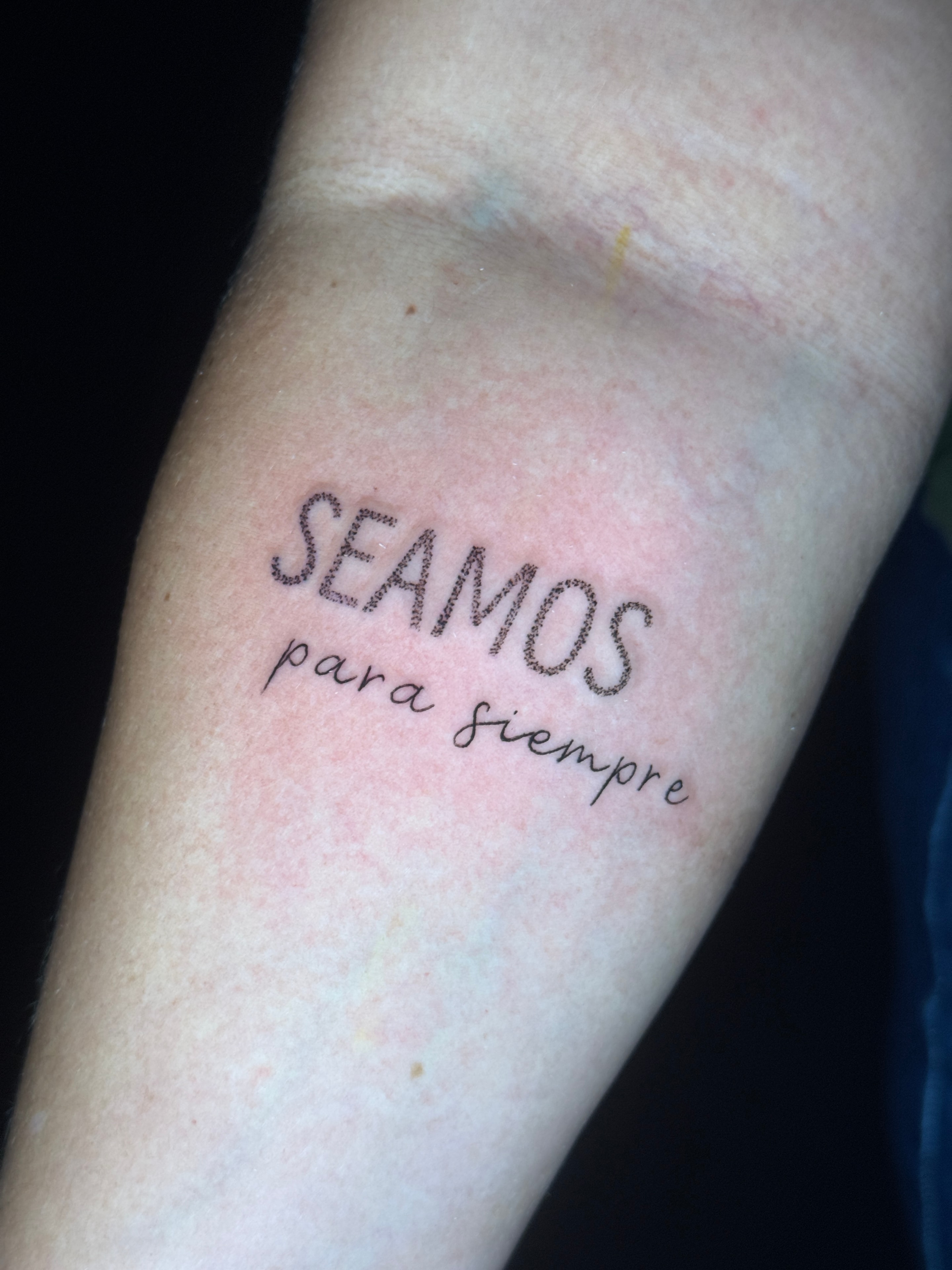 Tatuaje lettering SEAMOS para siempre en antebrazo