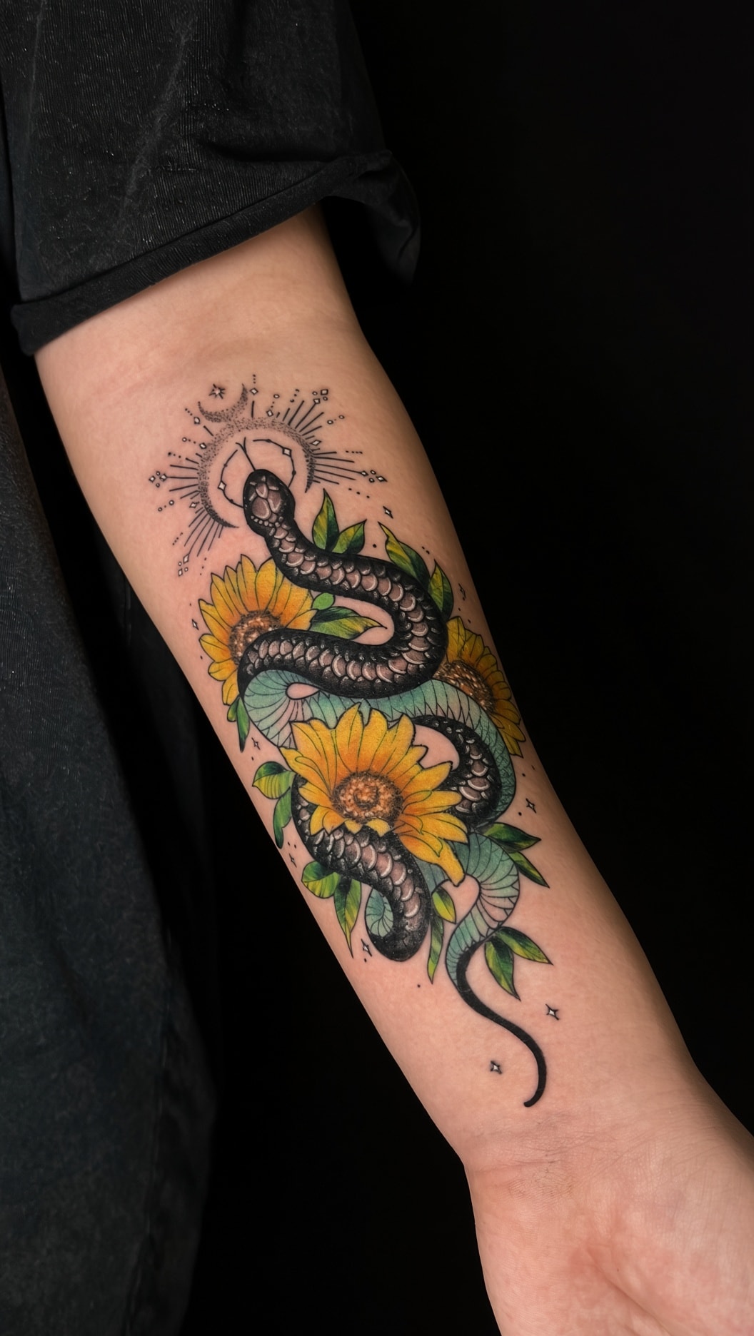 Tatuaje ornamental de serpiente y girasoles en antebrazo