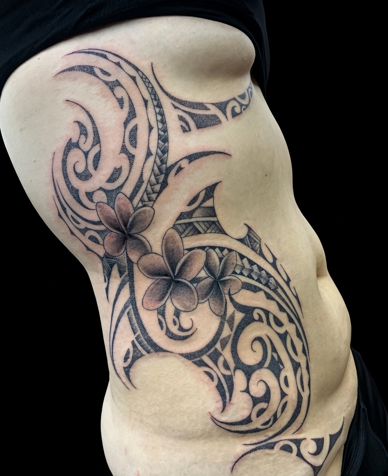 Tatuaje polinesio ornamental y floral en torso